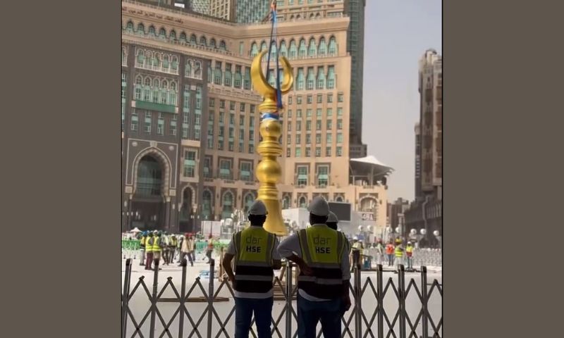 Raising the new golden crescent on the minaret of King Abdul Aziz gate of Masjid Al Haram